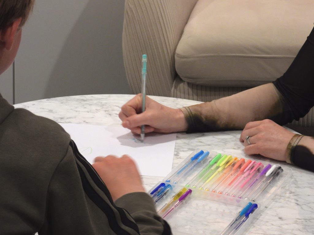 Therapist and patient drawing with coloured pens