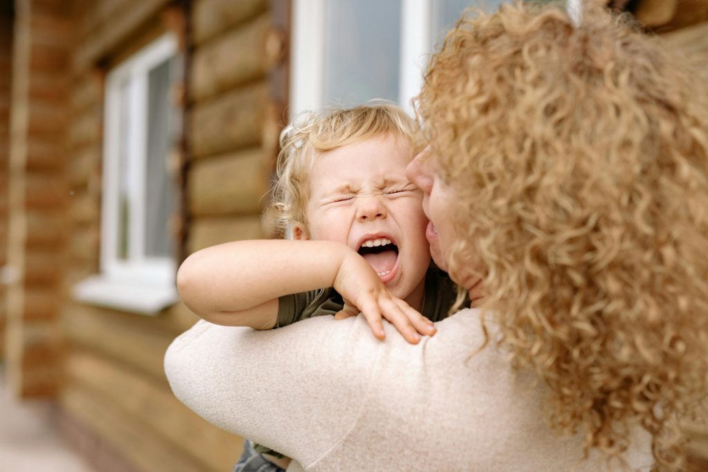 child crying in its mother's arms