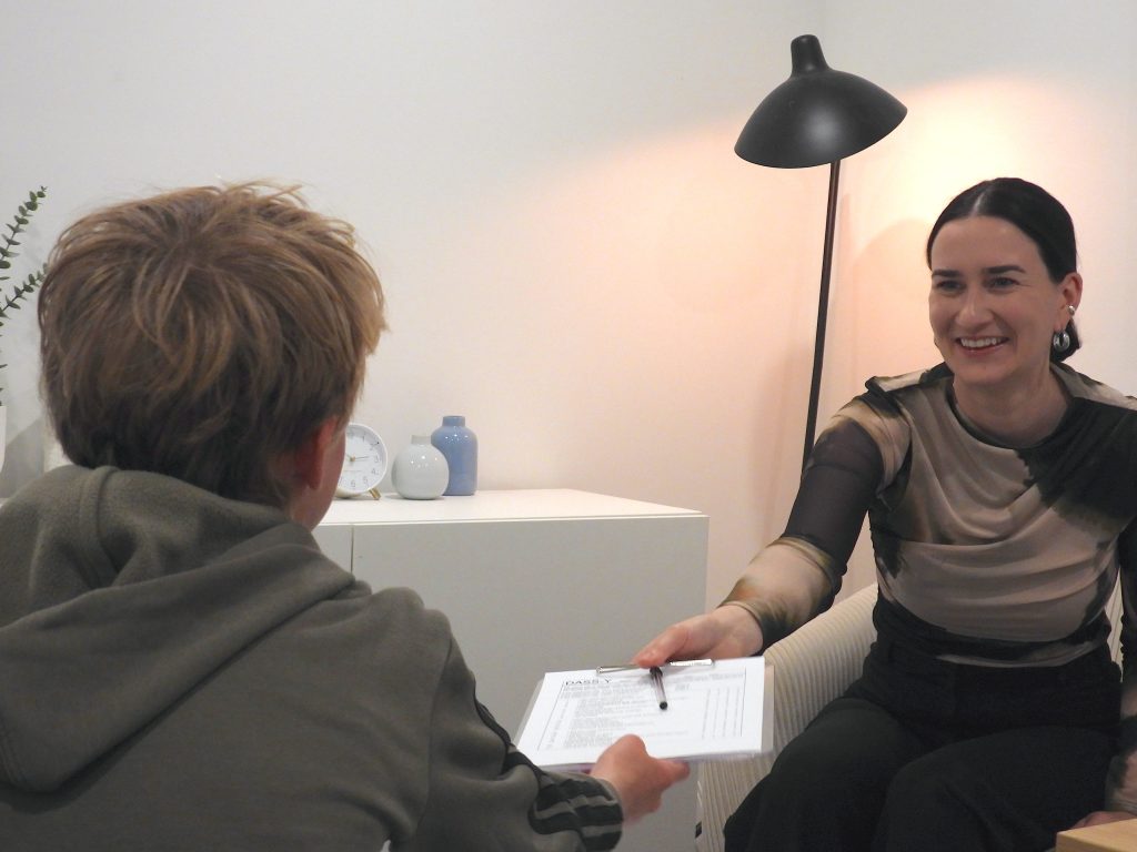 Smiling therapist handing a form to a patient